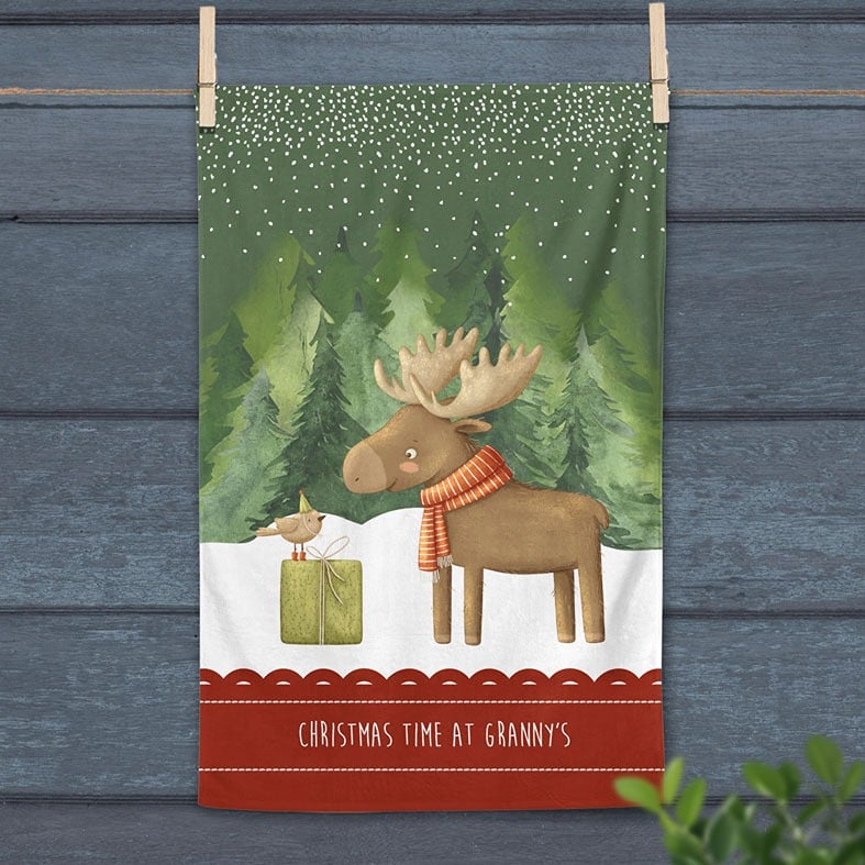 Personalised cotton Christmas tea towel in dark green and red with snowy friendly reindeer illustration