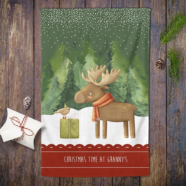 Personalised cotton Christmas tea towel in dark green and red with snowy friendly reindeer illustration