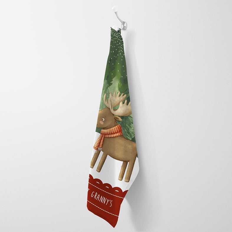 Personalised cotton Christmas tea towel in dark green and red with snowy friendly reindeer illustration