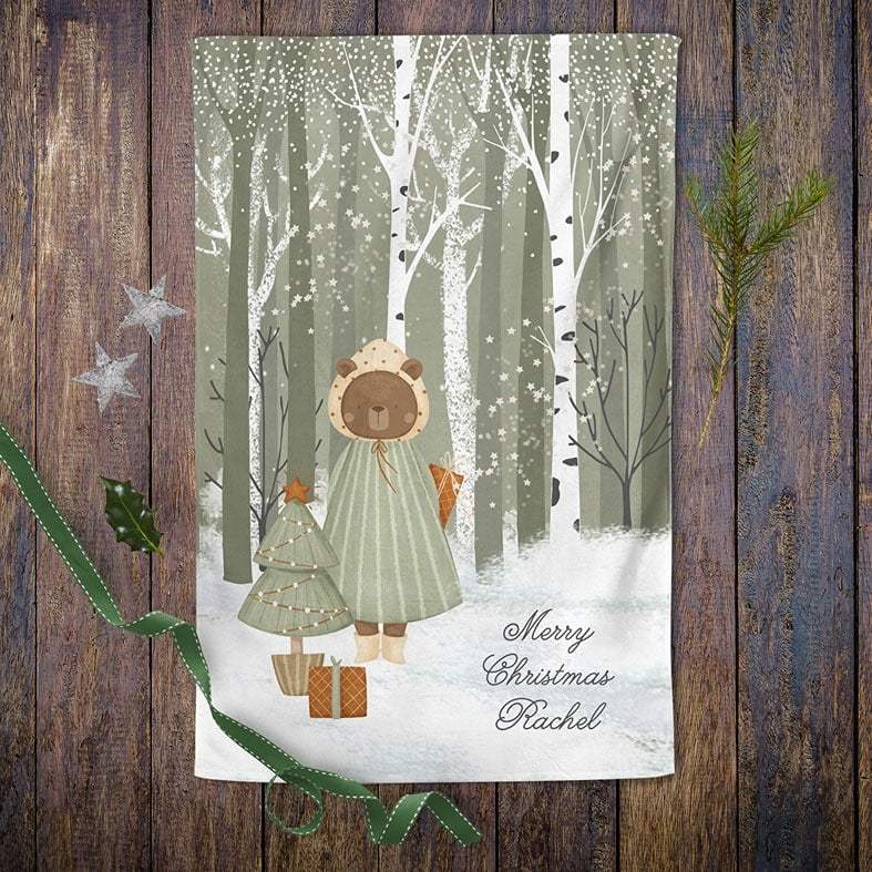 Personalised cotton Christmas tea towel in sage green and white with snowy hand-drawn festive illustration