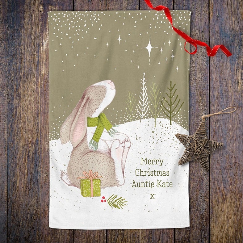Personalised cotton Christmas tea towel in sage green with snowy scene and sweet winter rabbit illustration