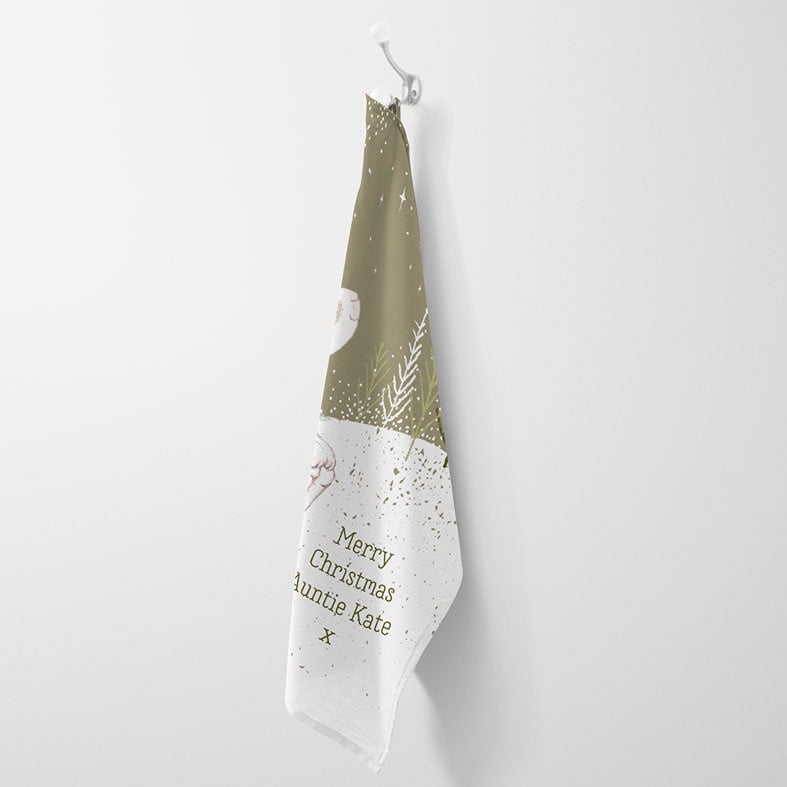 Personalised cotton Christmas tea towel in sage green with snowy scene and sweet winter rabbit illustration