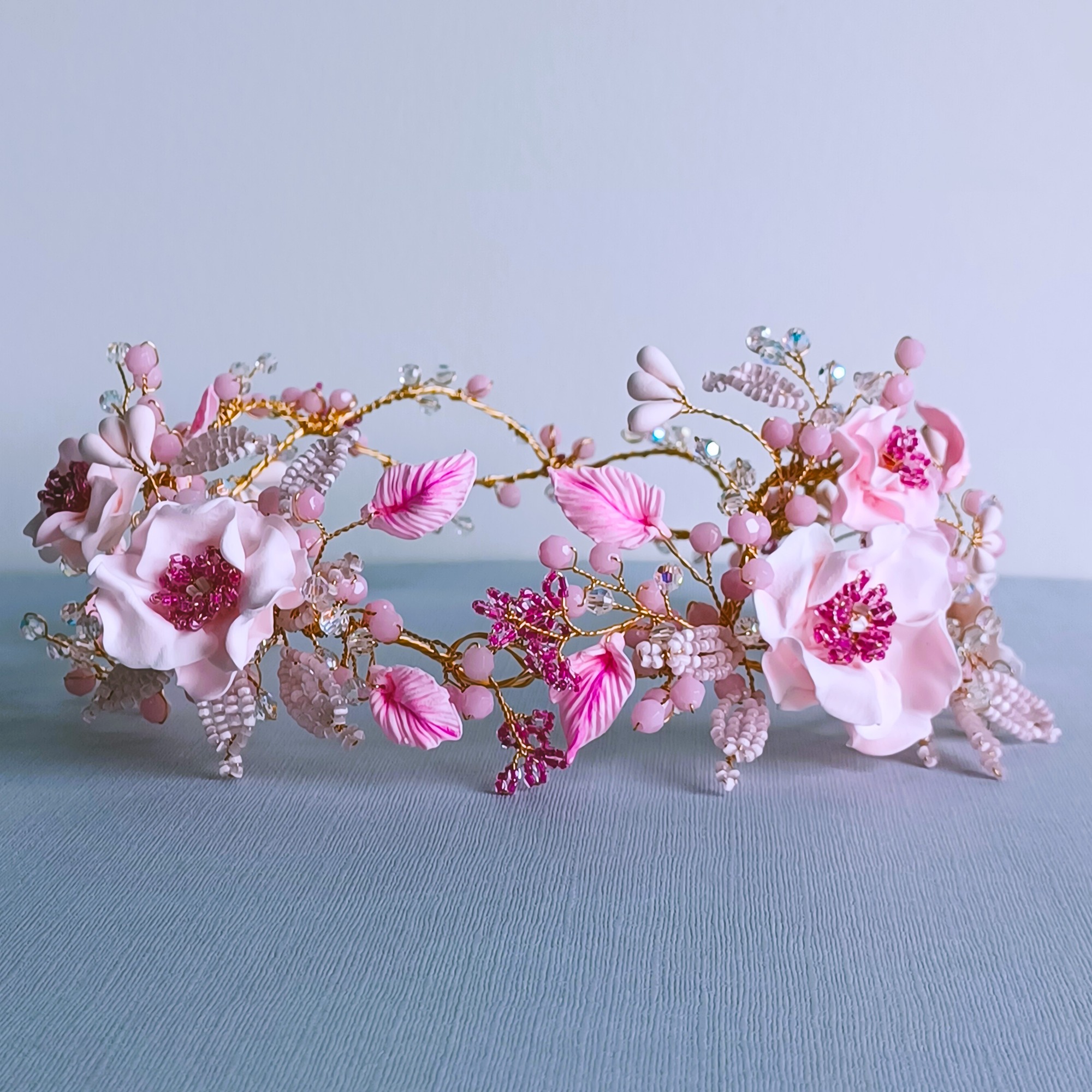 pink-floral-headgarland-handmade-with-pink-flowers-leaves-crystals-on-a-plain-background