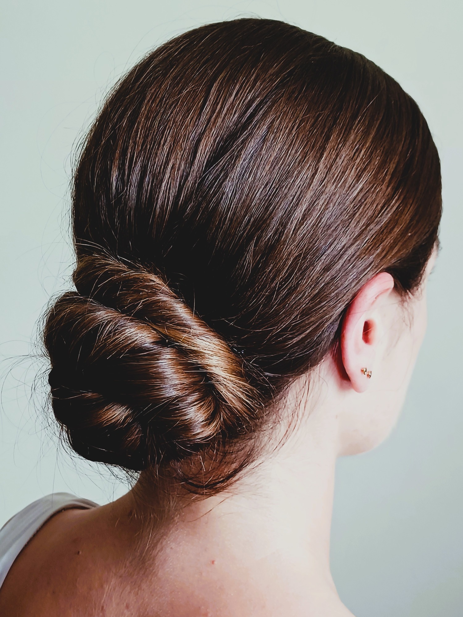 female-woman-bride-with-brunnette-hair-wearing-her-hair-in-a-rolled-classic-chignon-hairstyle-hair-is-rolled-into-the-nape