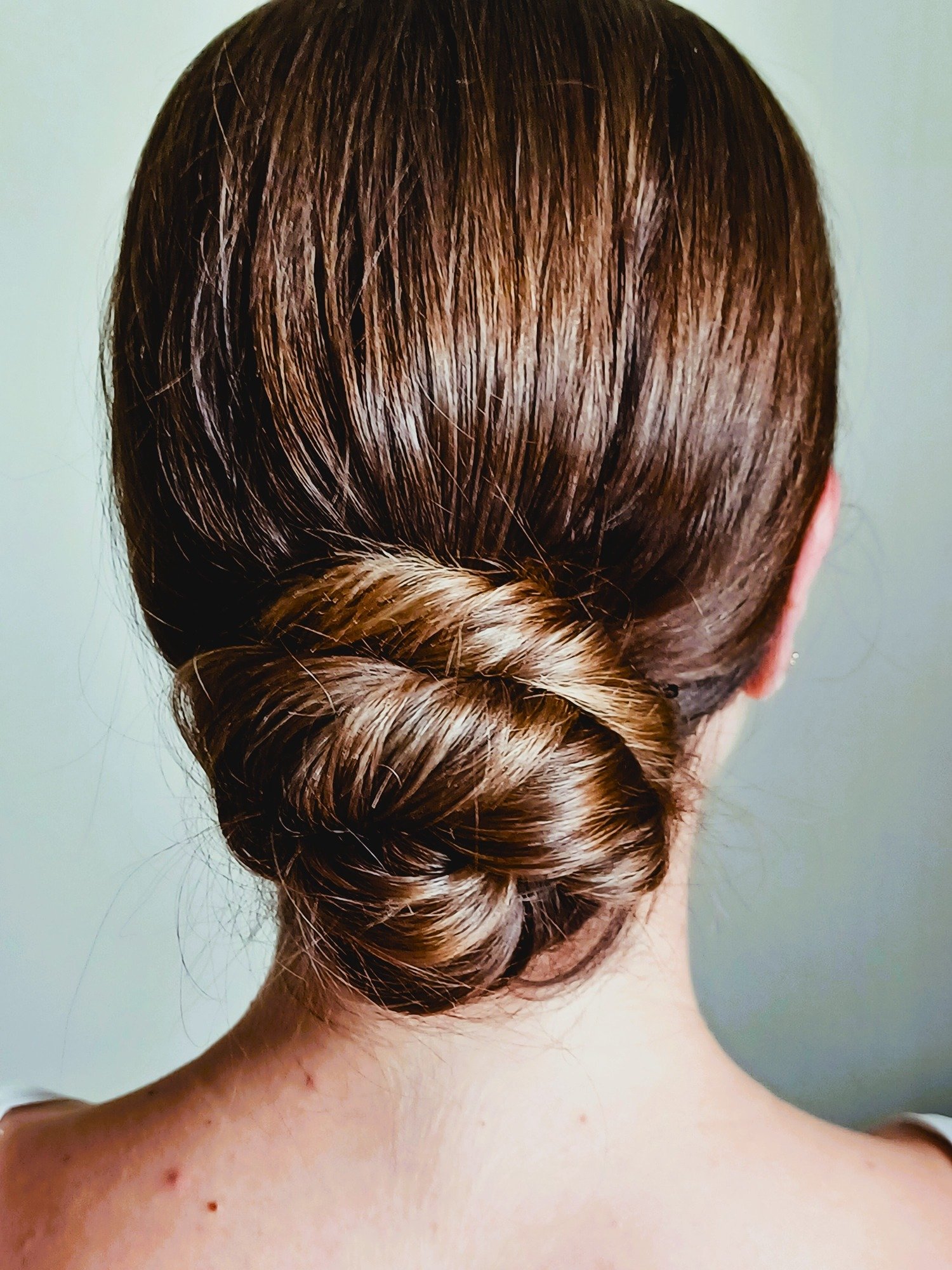 female-woman-bride-with-brunnette-hair-wearing-her-hair-up-in-an-elegant-rolled-classic-chignon-hairstyle-hair-is-rolled-into-the-nape-weddinghairstyle