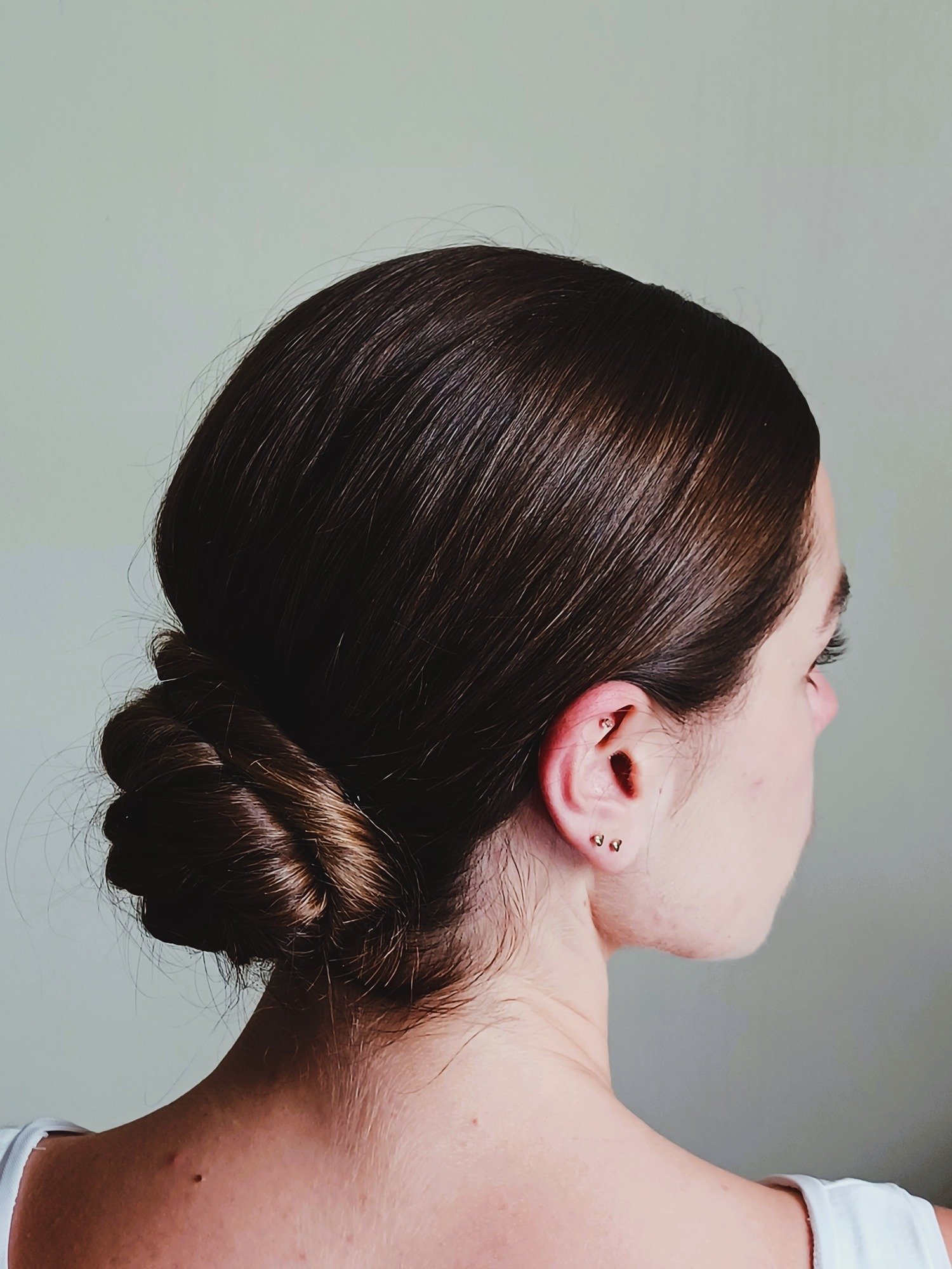 female-woman-bride-with-brunnette-hair-wearing-her-hair-up-in-an-elegant-rolled-classic-chignon-hairstyle-hair-is-rolled-into-the-nape-weddinghairstyle