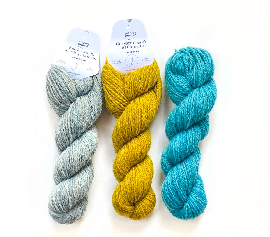 three skeins of Hampshire DK yarn in Dragonfly colourway lying on white background