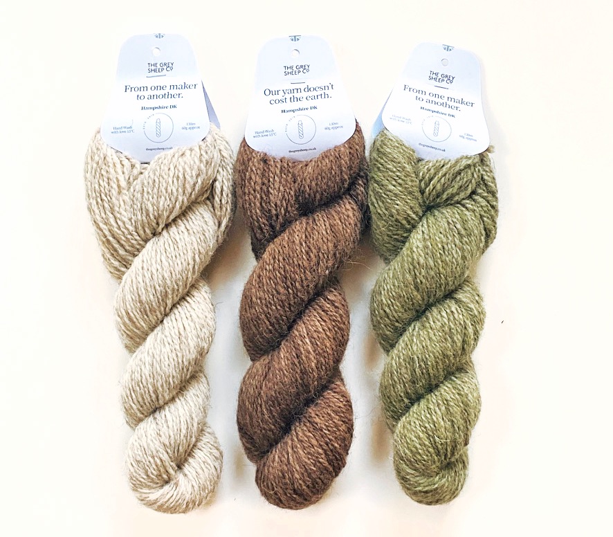 three skeins of Hampshire DK yarn in In Neutral colourway lying on white background