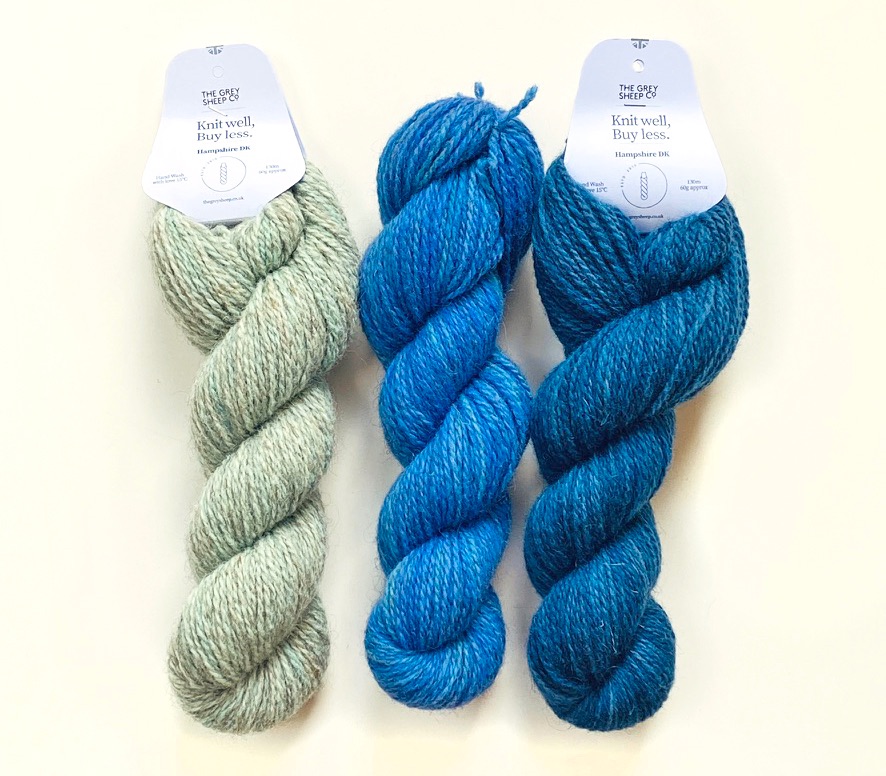 three skeins of Hampshire DK yarn in The Blues colourway lying on white background