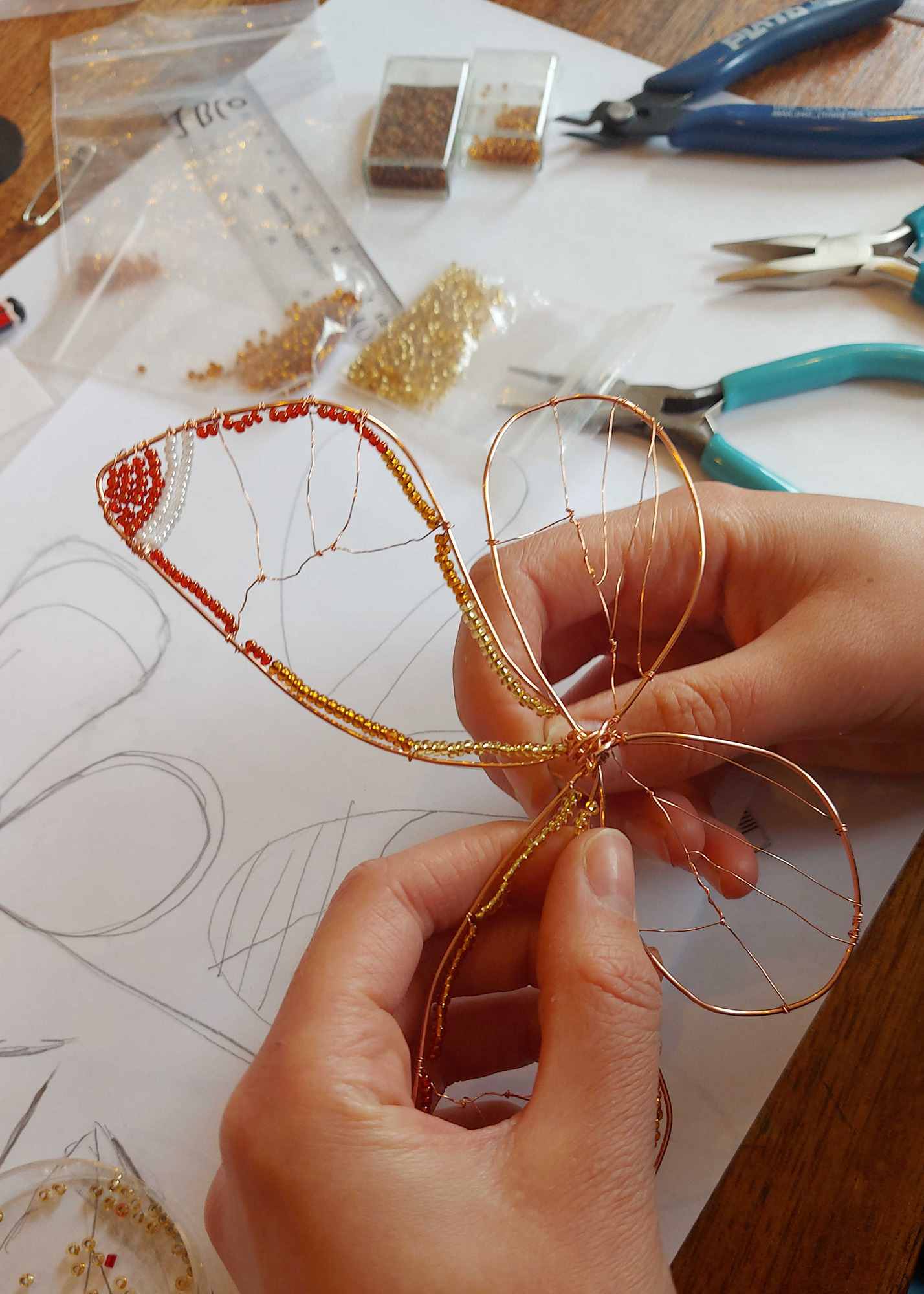 Hands at work makinh a wire and bead butterfly on a workshop with Judith Brown in staffordshire