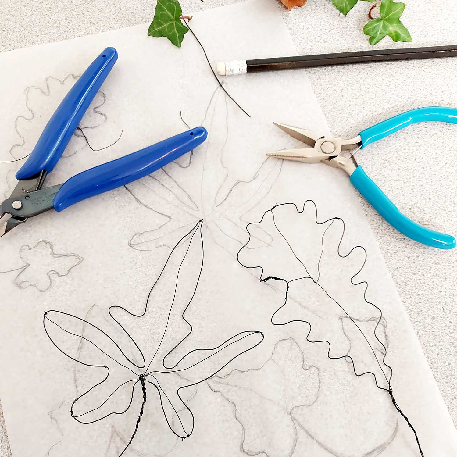 A workshop table with pliers, and wire leaves being made on a nature inspired workshop