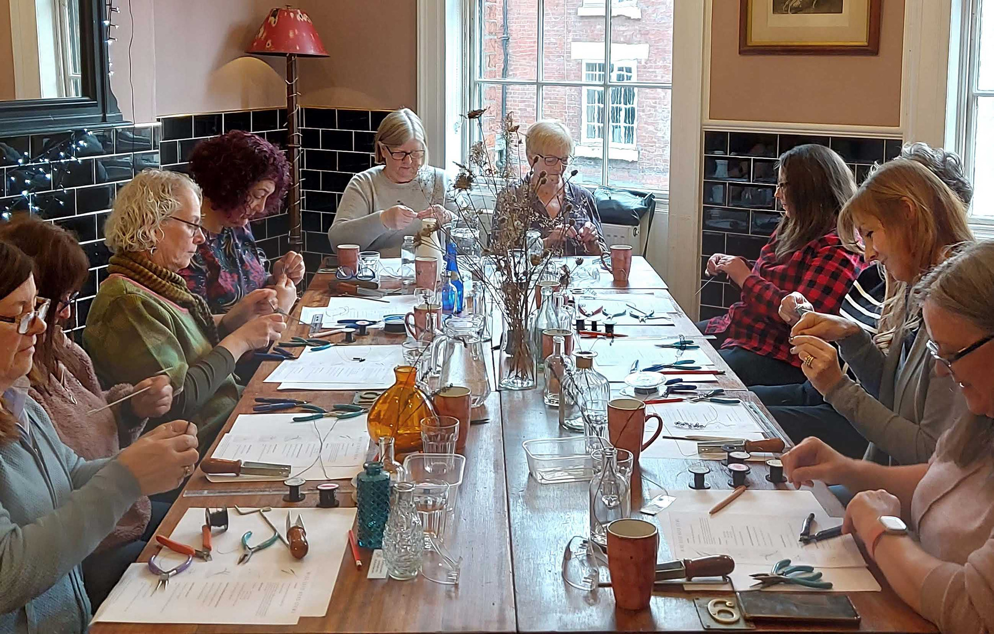 A table surrounded by people busy making things on a craft workshop