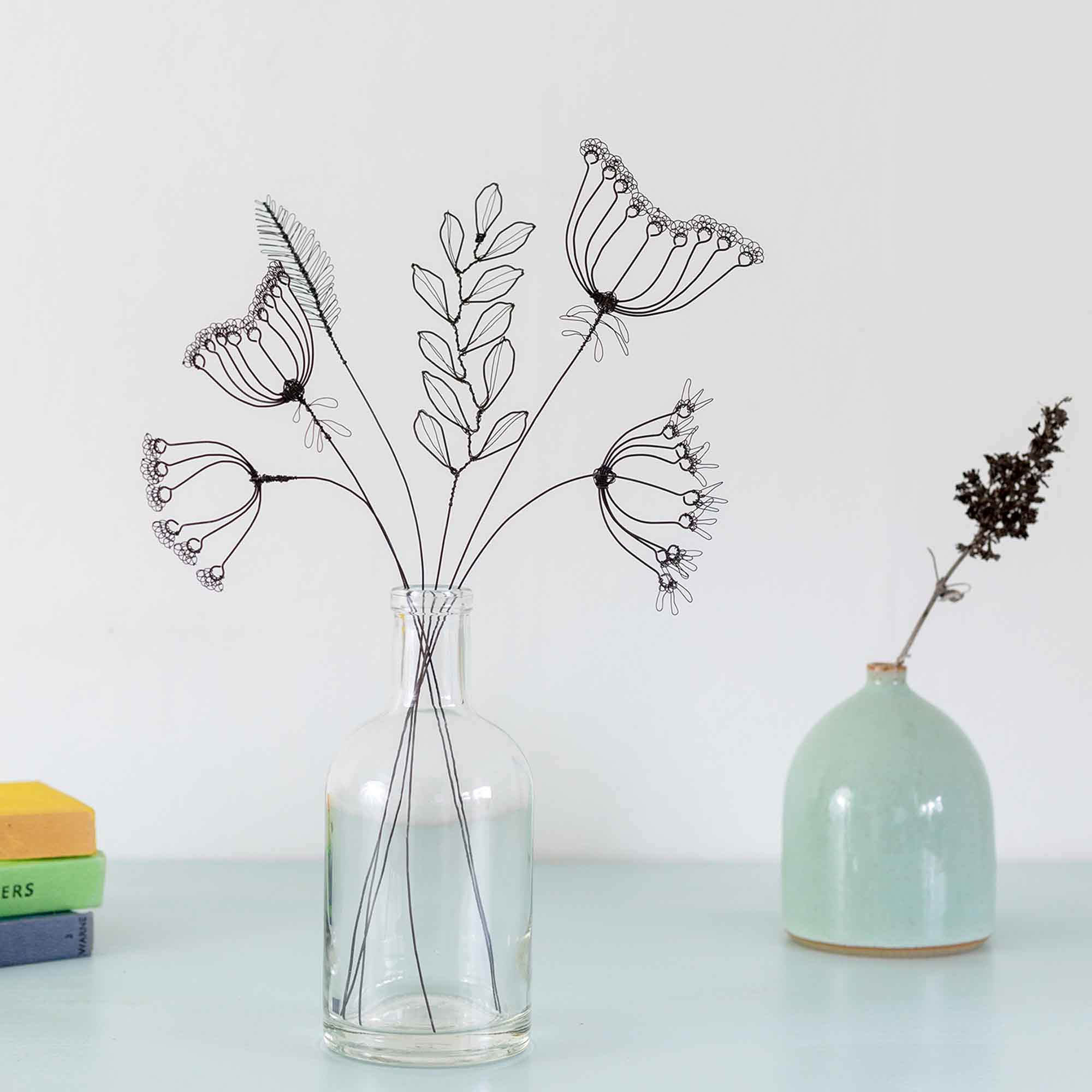 Wire flower in a glass bottle inspired by seedheads and grasses