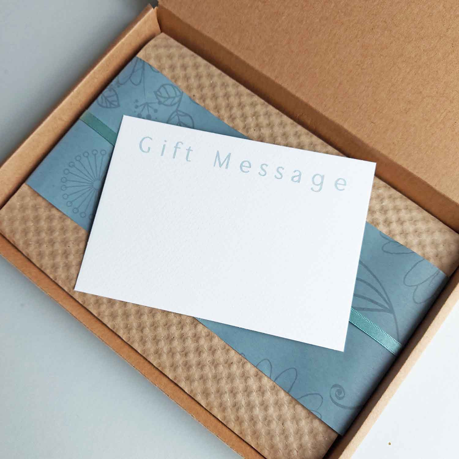 a brown packaging box, showing the inside finishe with wrapping paper, ribbon and a gift message