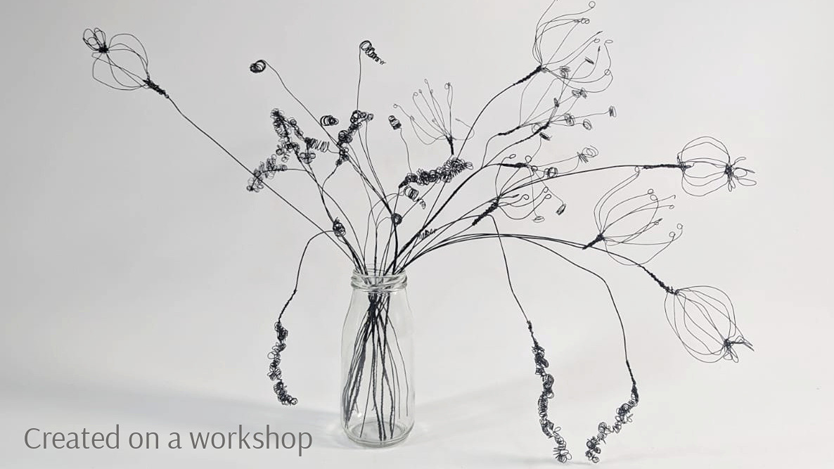 Wire seed heads displayed in a jar, includes poopy seed heads, grasses and cow parsley