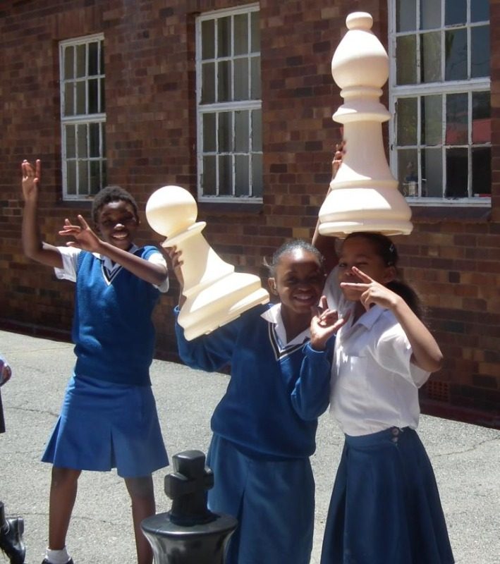 happy girls and chess pieces