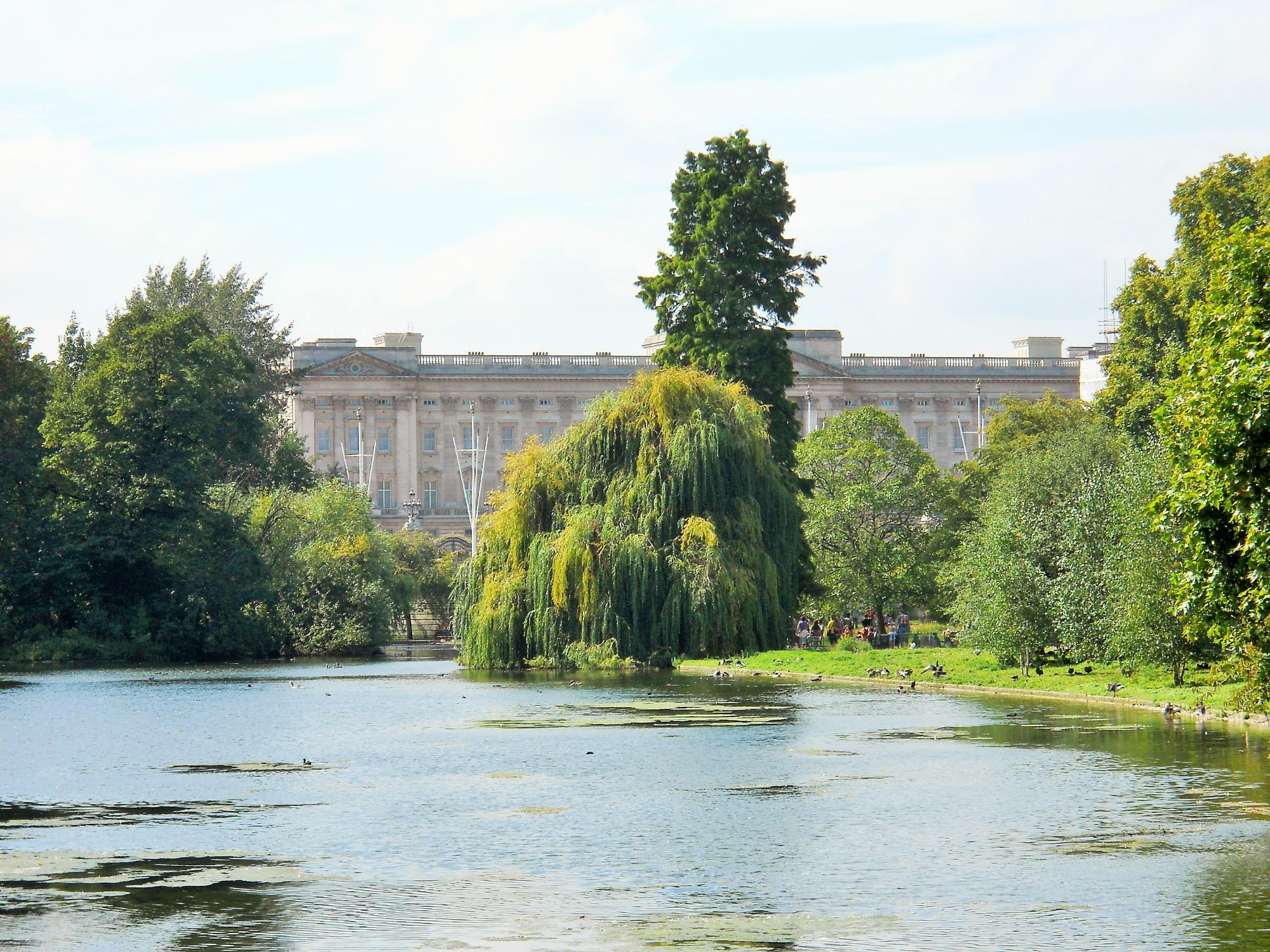 Photo of Buckingham Palace. With St James's Park in the foreground, with its lake and trees.