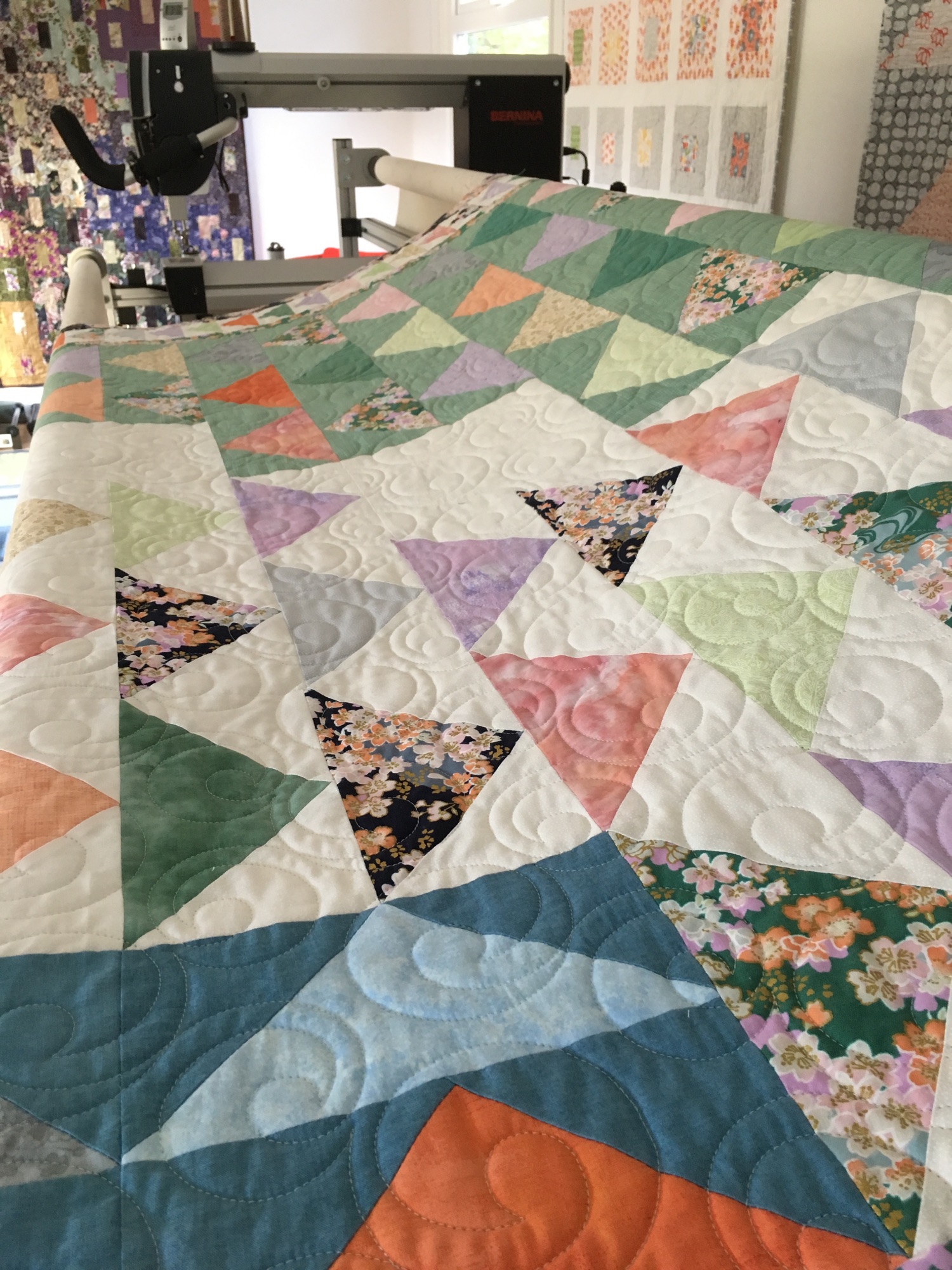 [picture of a triangle quilt quilted with a spiraling pantograph