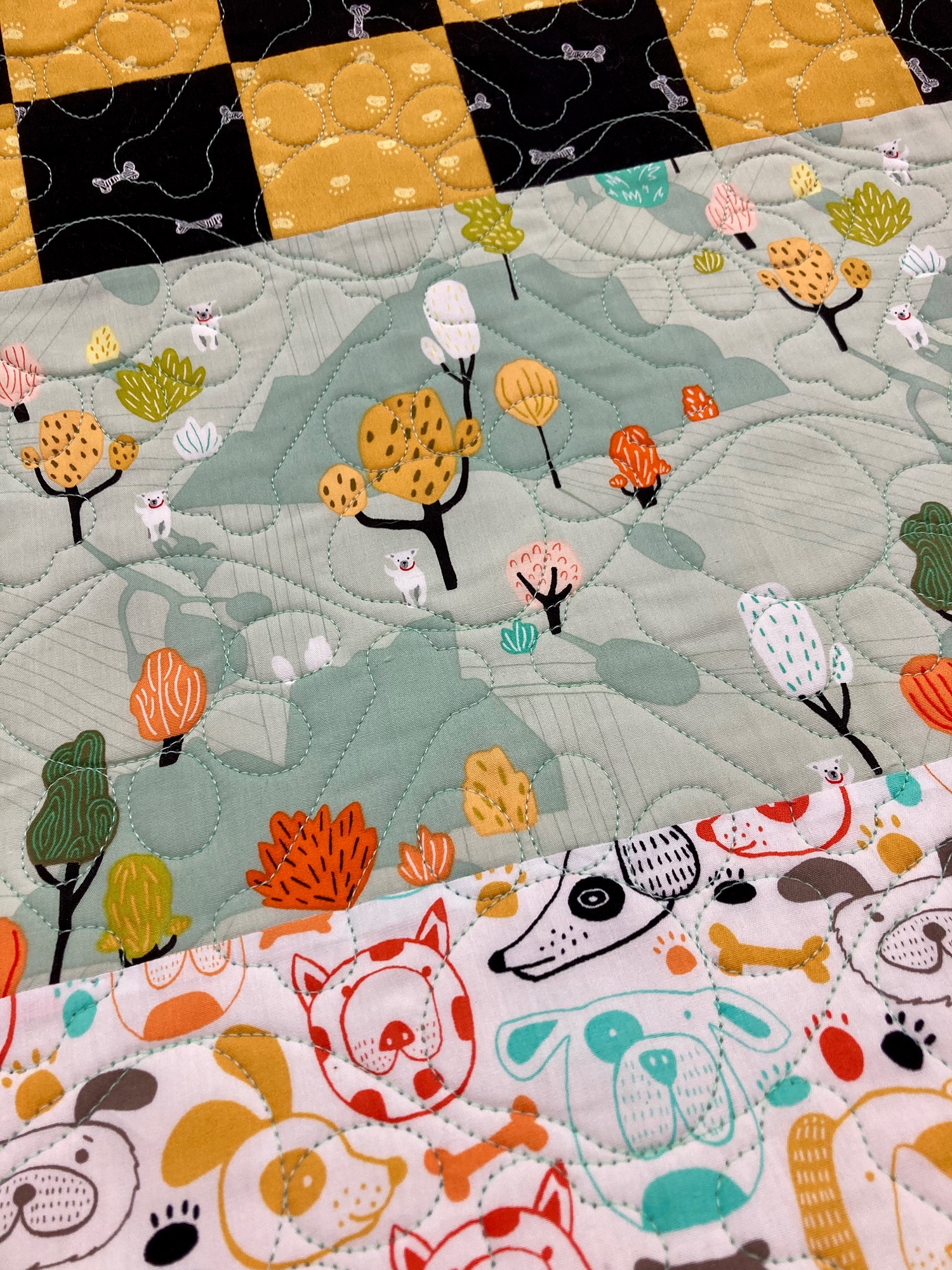 Image of a childs quilt with stitched bones and paws