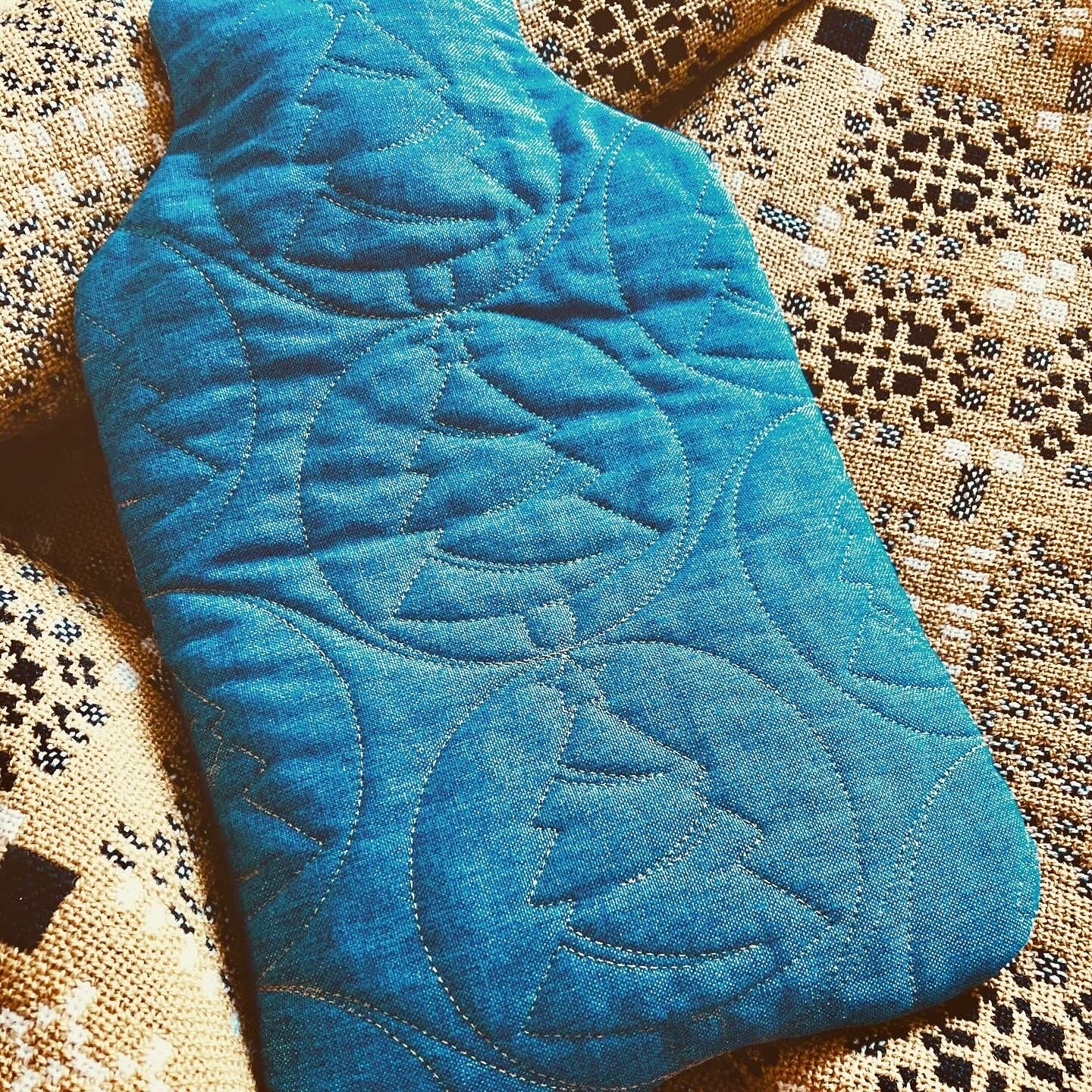 Image of a quilted waterbottle cover on a woolen blanket