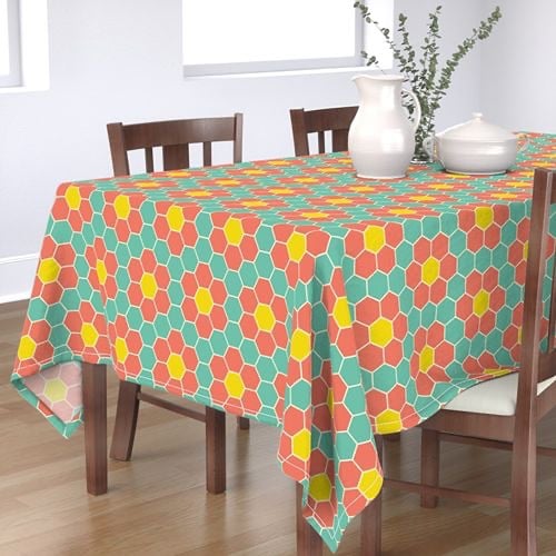 Image of a table with a turquoise and coral tablecloth and white vase 