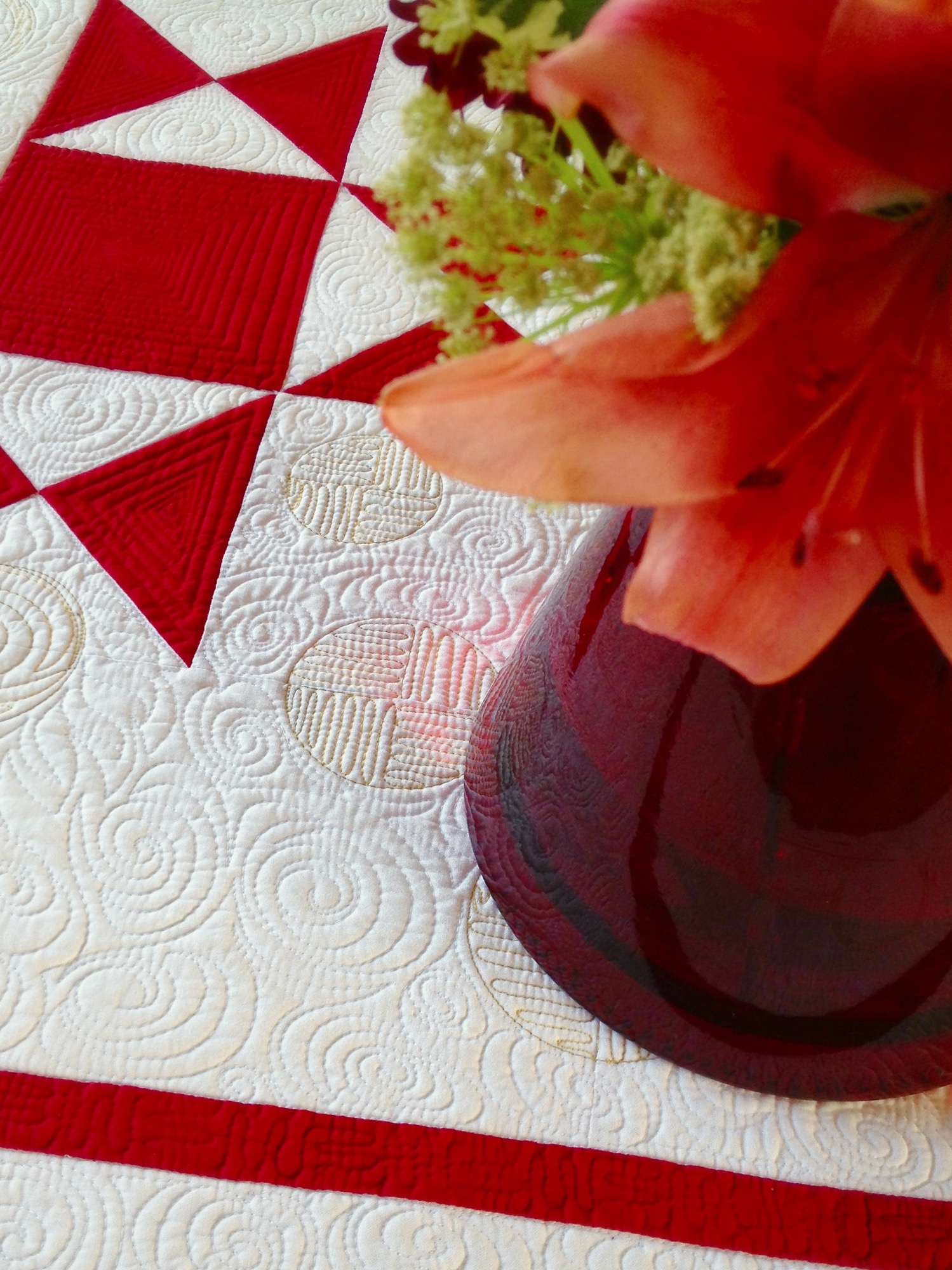 Traditional appliqu&Atilde;&copy; quilt with custom longarm quilting in muted red, green, and tan, showing borders, blocks, and background filler designs