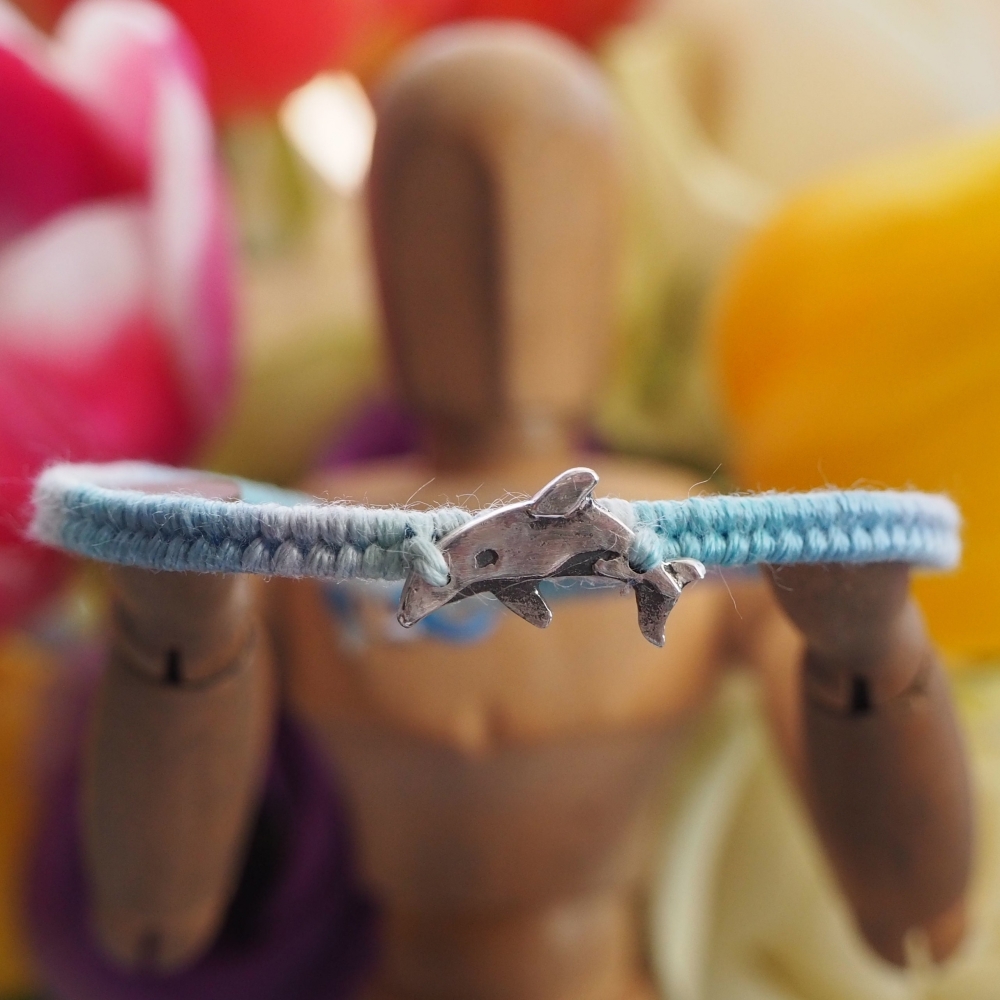 Fine silver orca charm on a blue friendship bracelet