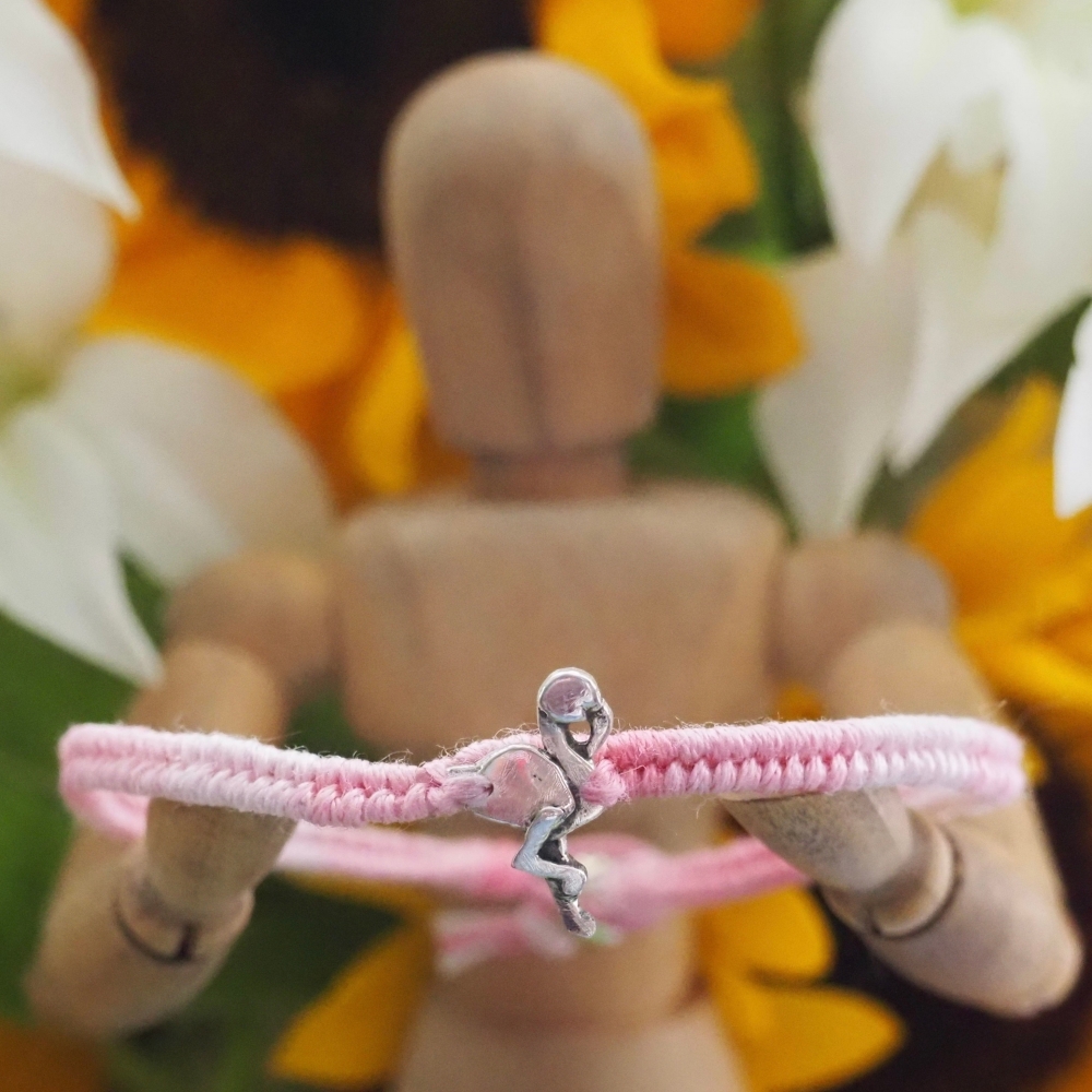 Fine silver flamingo charm on a pink friendship bracelet