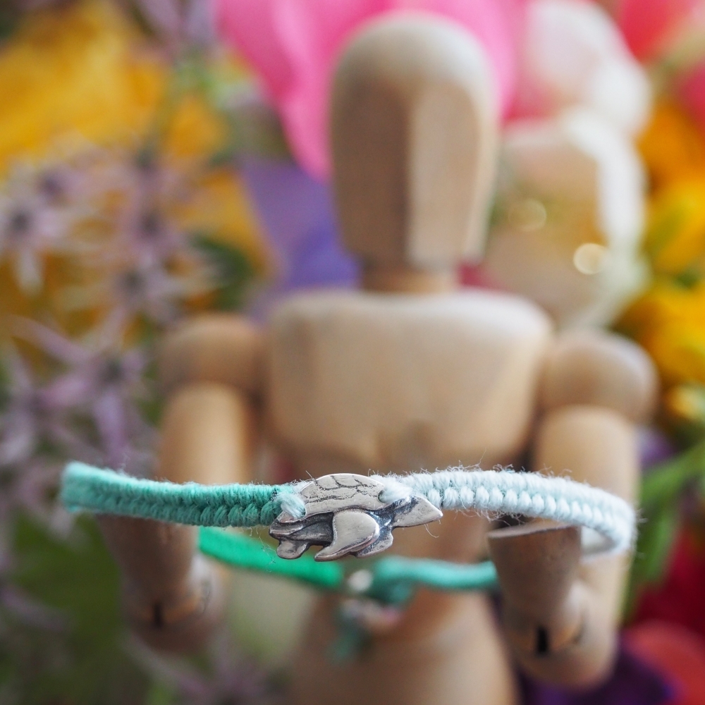 Fine silver sea turtle charm on a turquoise friendship bracelet