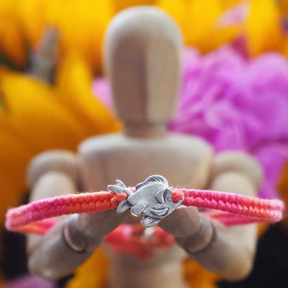 Fine silver goldfish charm on a red/orange friendship bracelet