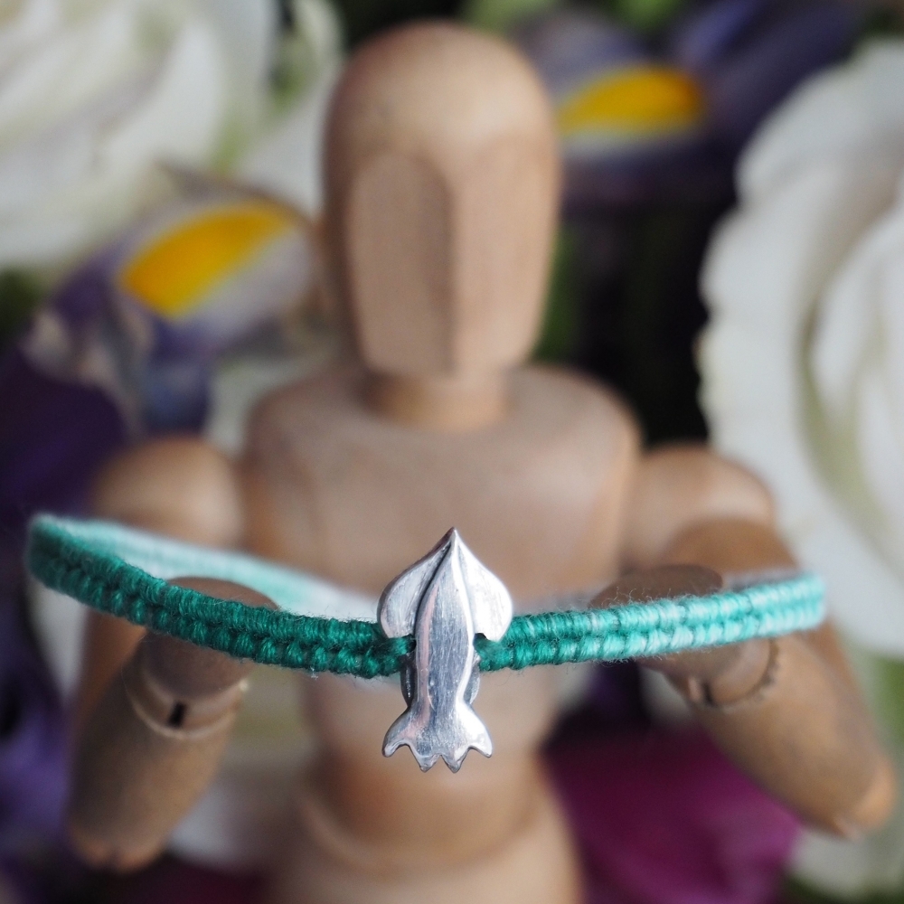 Fine silver squid charm on a green friendship bracelet