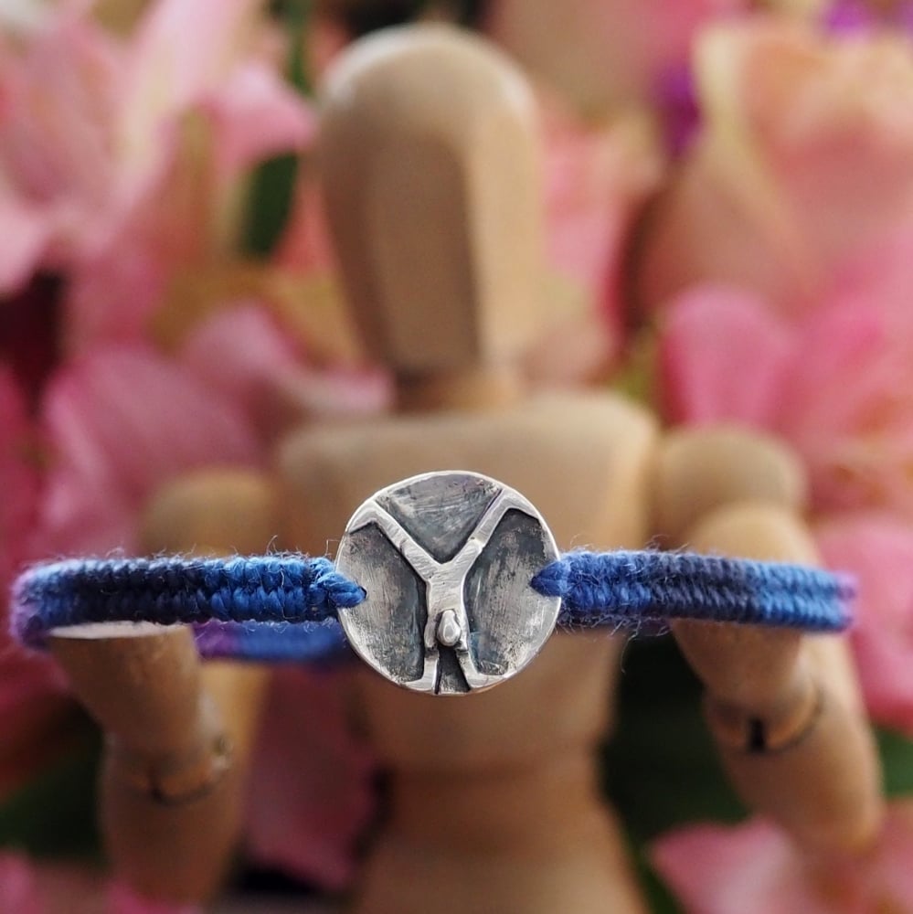 Fine silver disc charm with gymnast stamp on a deep blue friendship bracelet