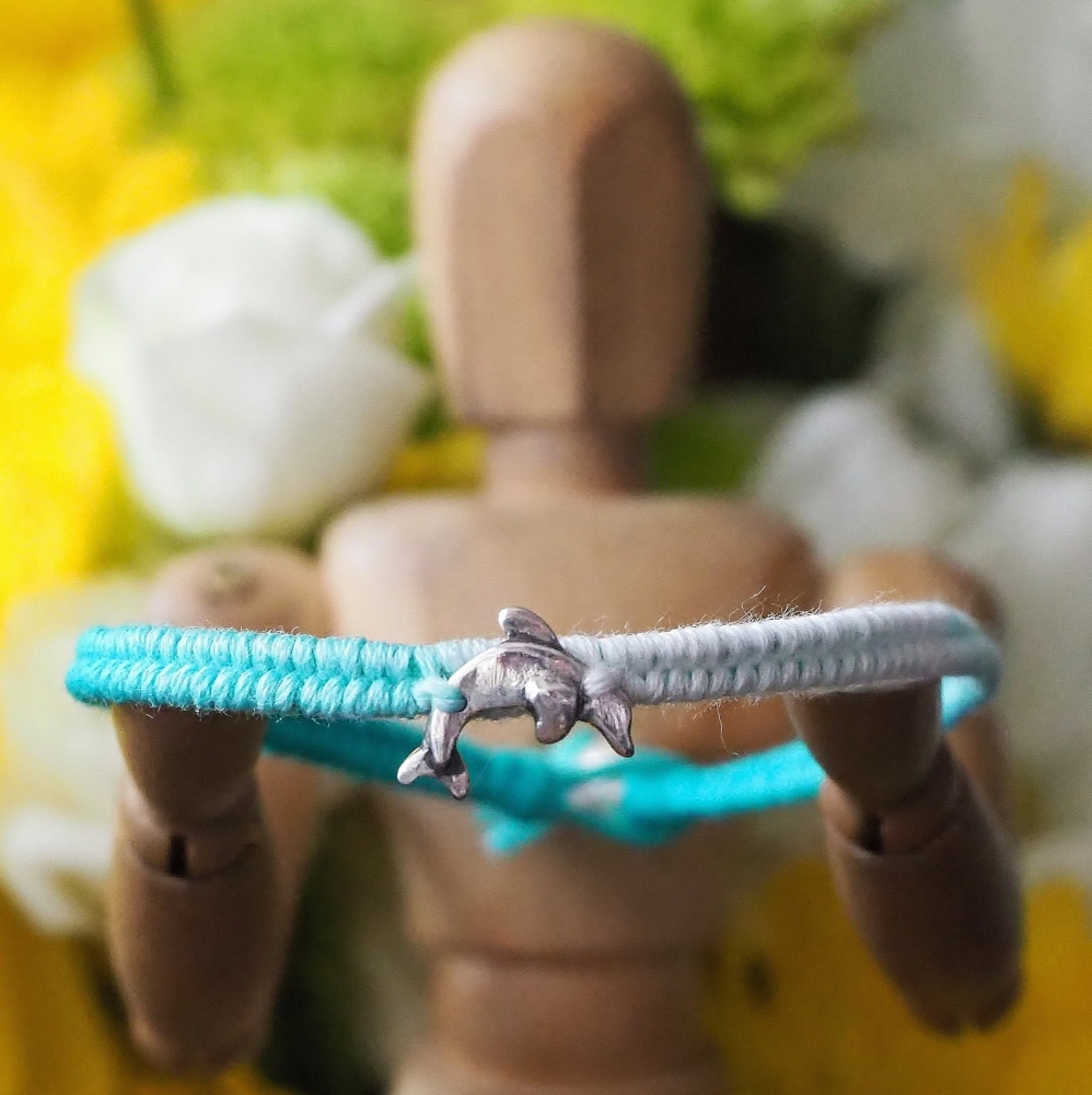 Fine silver dolphin charm on a turquoise friendship bracelet