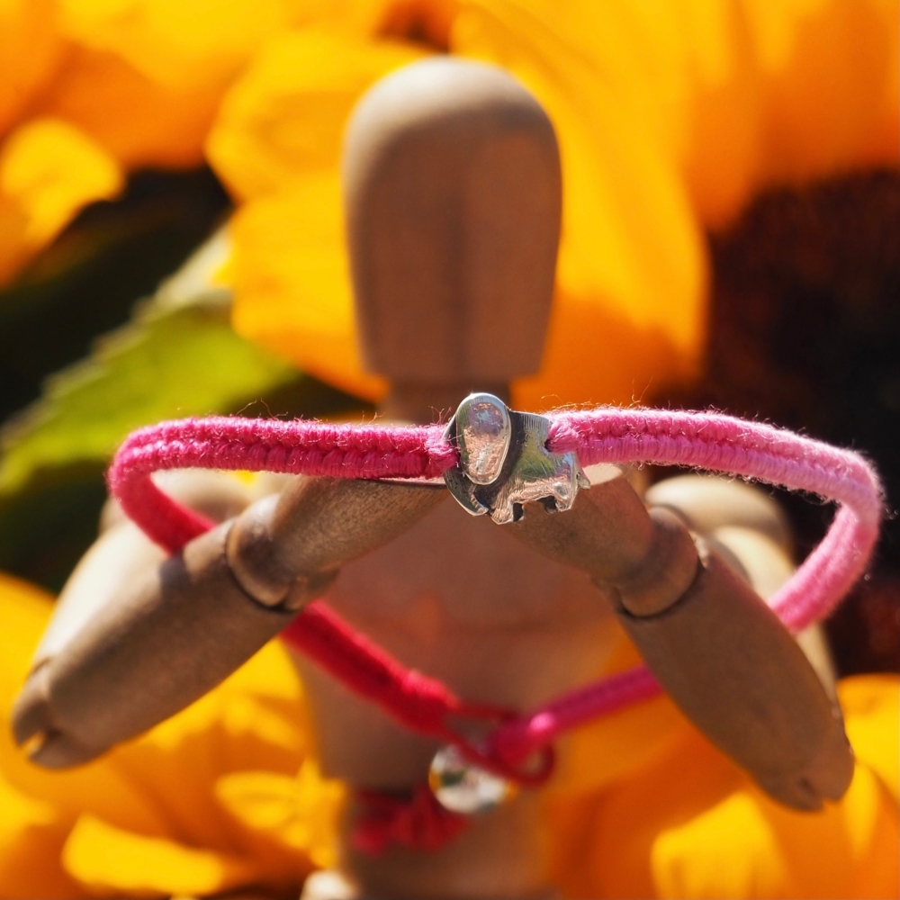 Fine silver elephant charm on a pink/red friendship bracelet