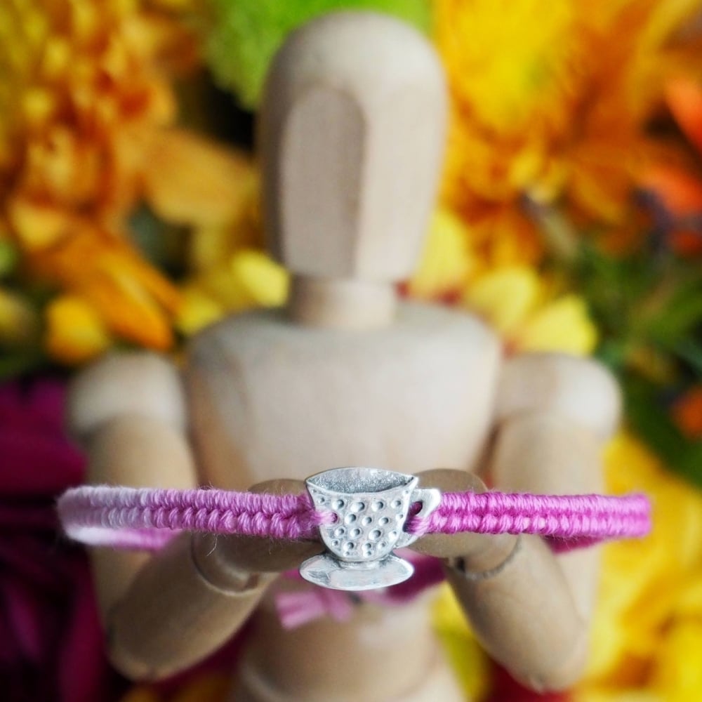 Fine silver teacup charm on a pink friendship bracelet