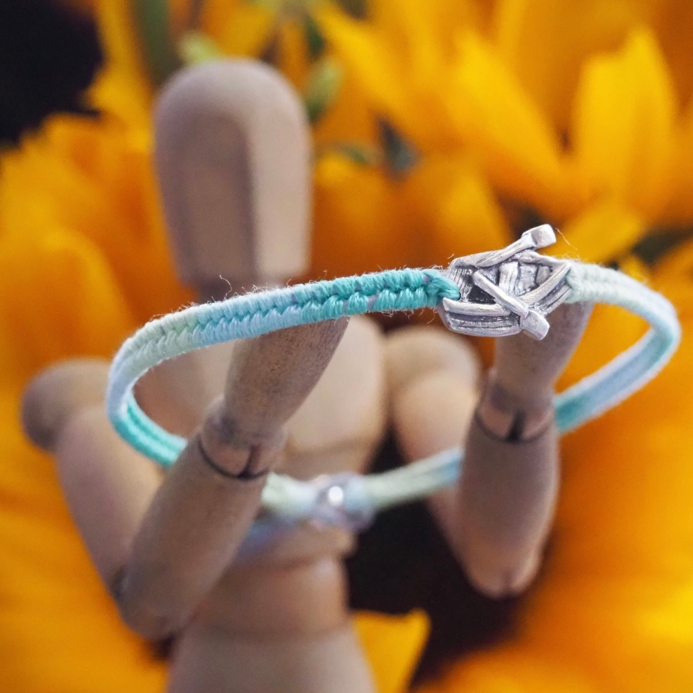 Fine silver rowing boat charm on a blue/green friendship bracelet