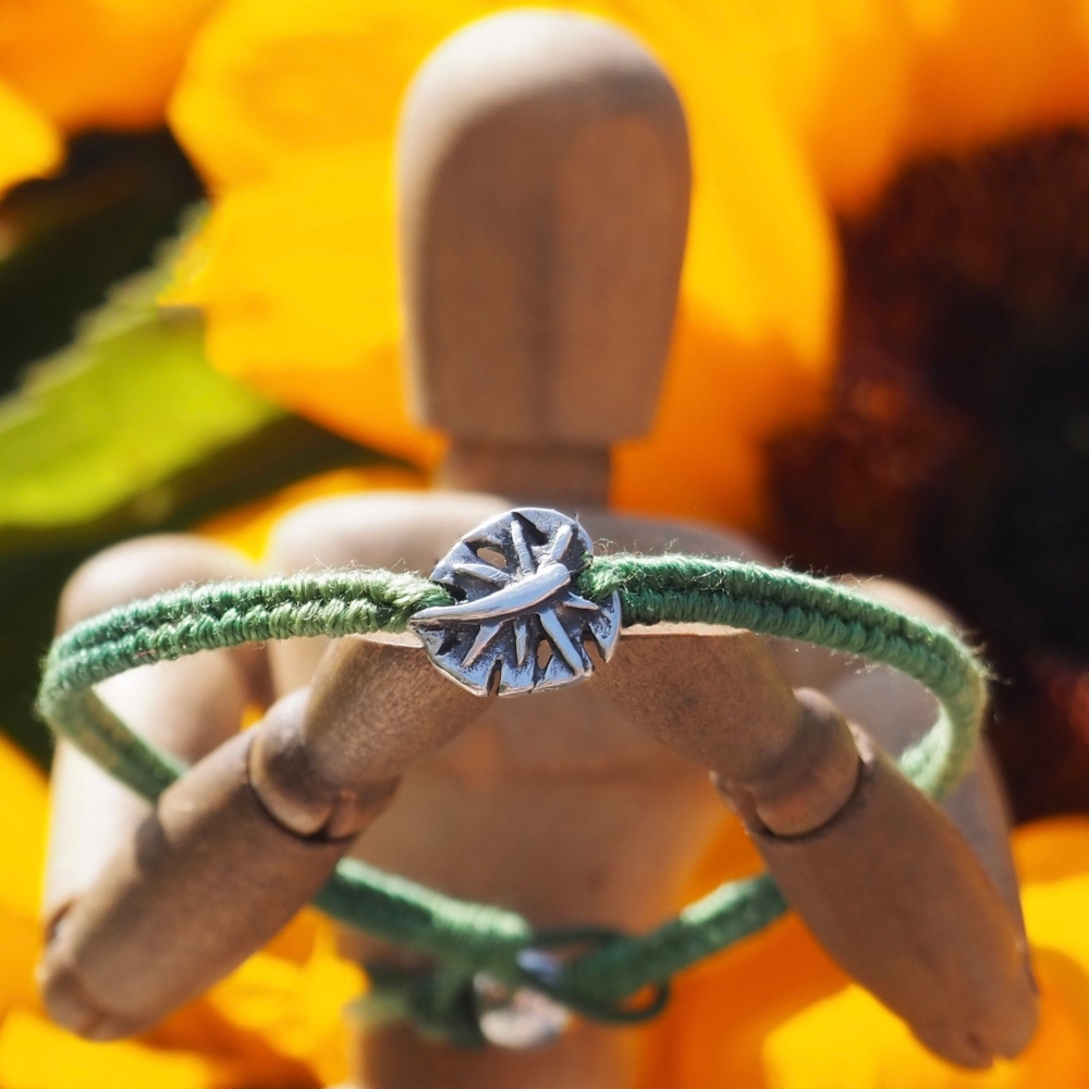 Fine silver monastera leaf charm on a olive green friendship bracelet