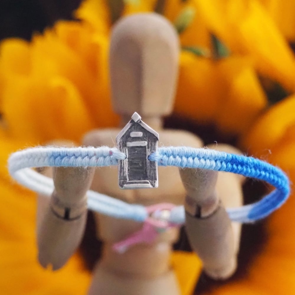 Fine silver beach hut charm on a vivid blue friendship bracelet