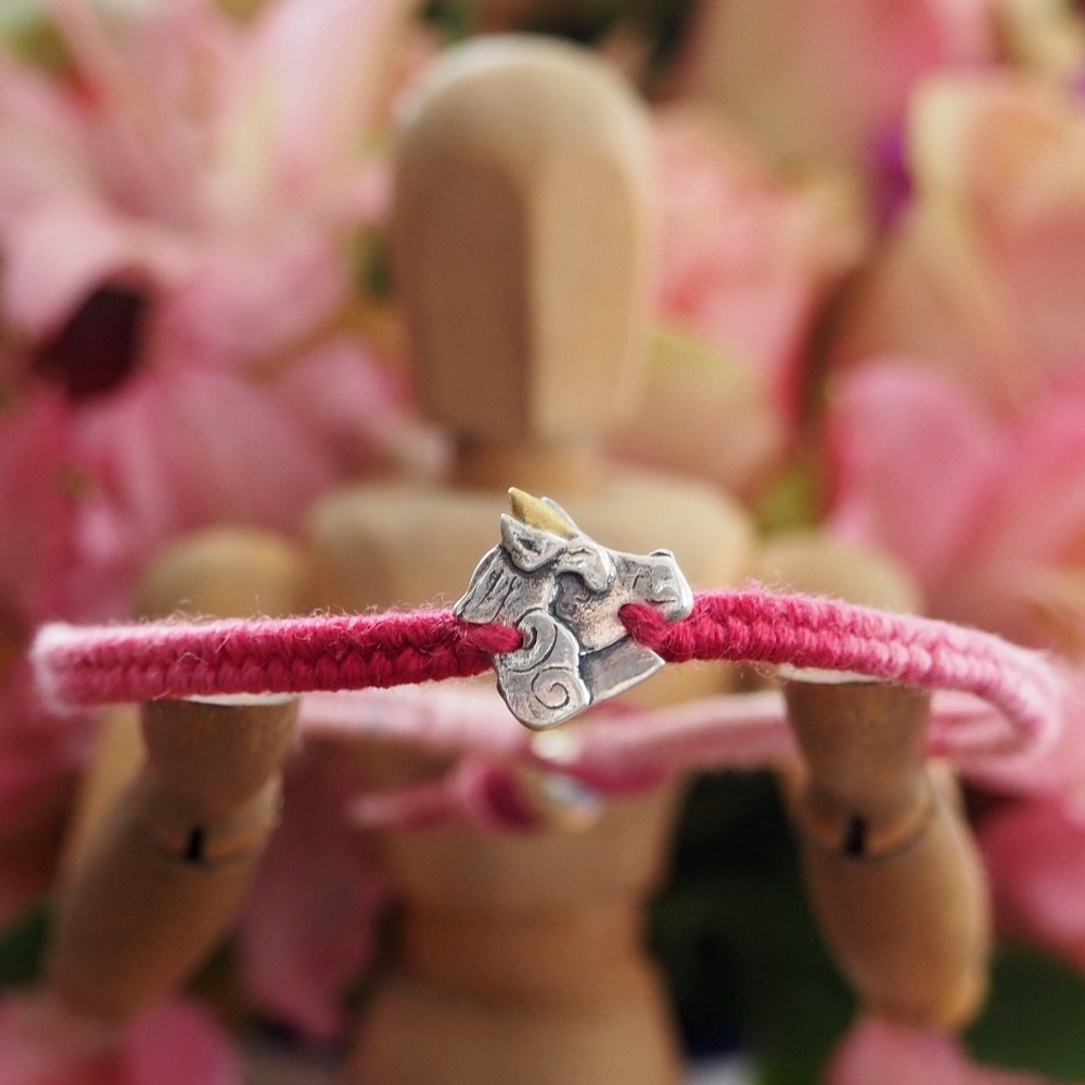 Fine silver unicorn charm on a pink friendship bracelet