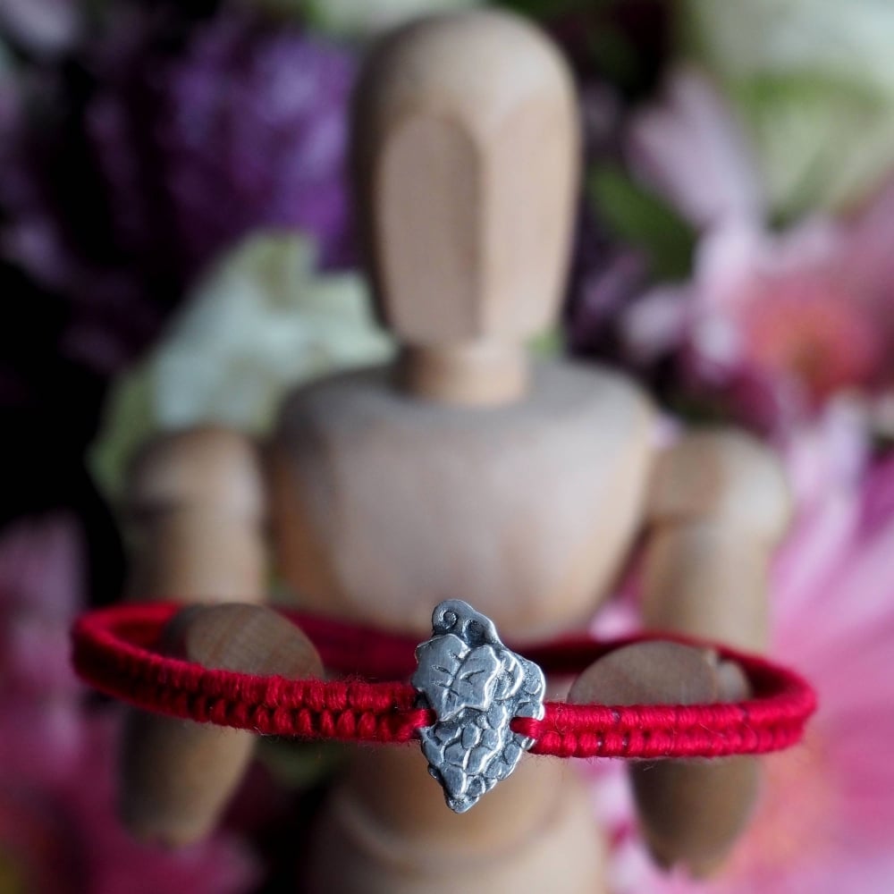 Fine silver grapes charm on a red friendship bracelet