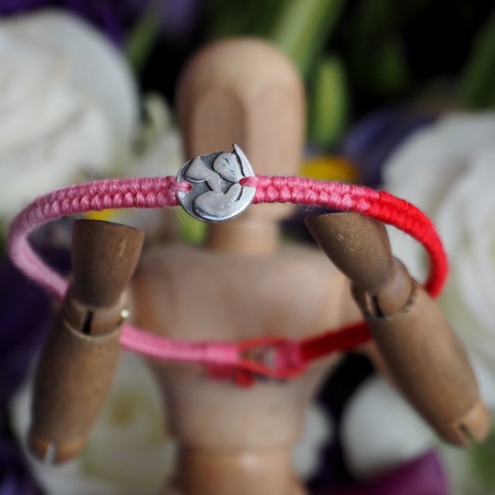 Fine silver otter charm on red friendship bracelet