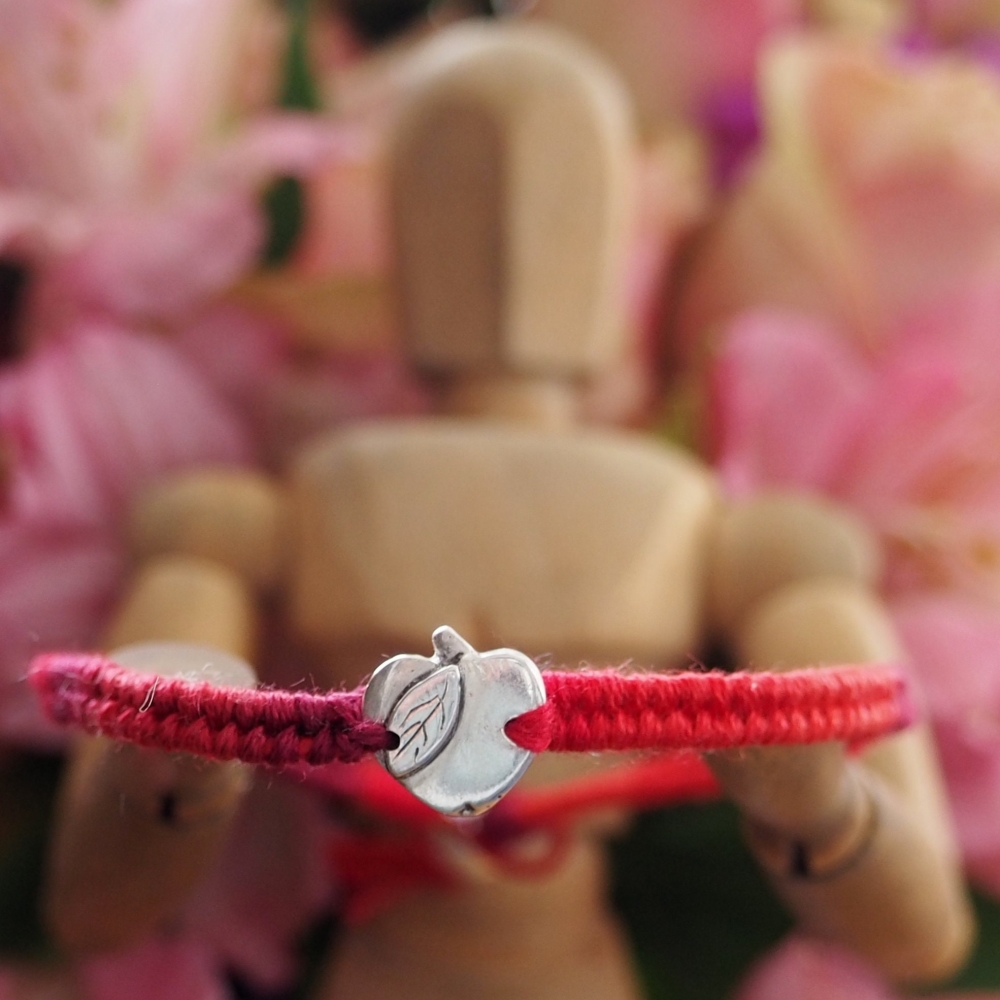 Fine silver apple charm on a red friendship bracelet