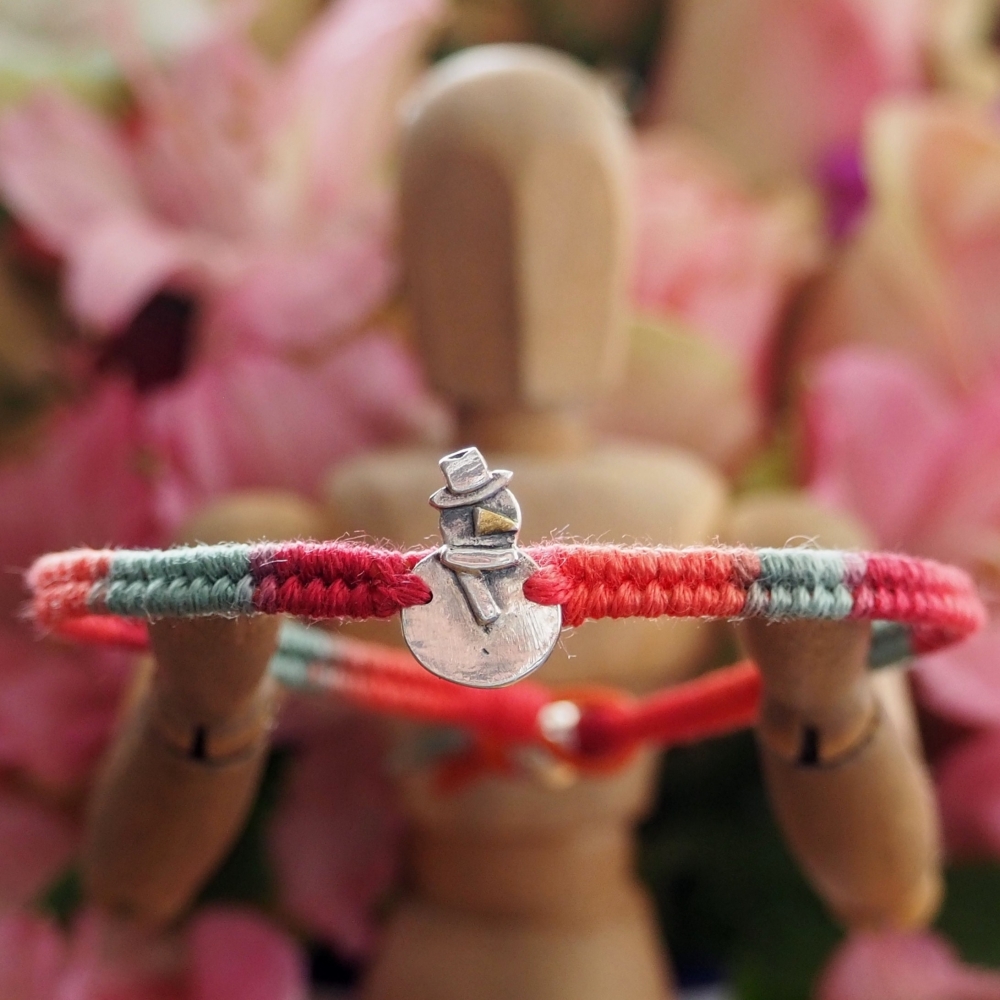 Fine silver snowman charm on a red friendship bracelet