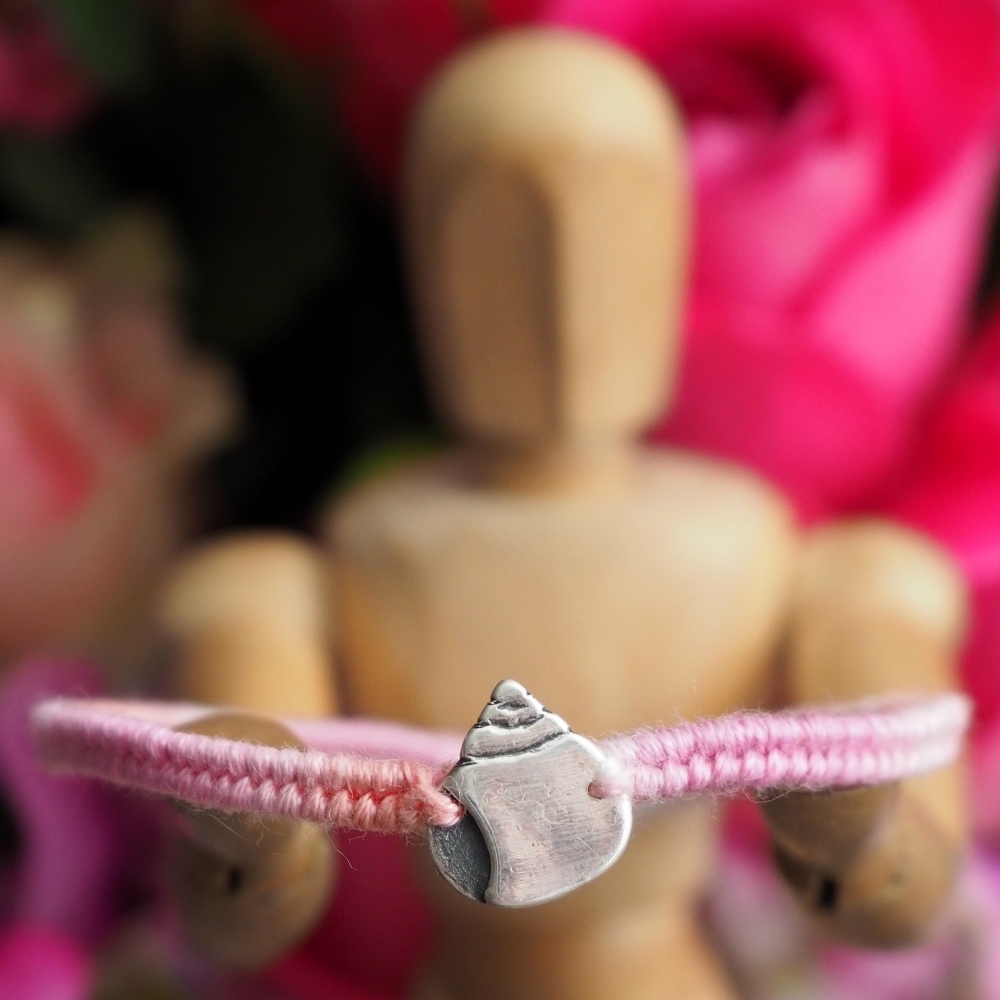 Fine silver snail shell charm on a pink friendship bracelet
