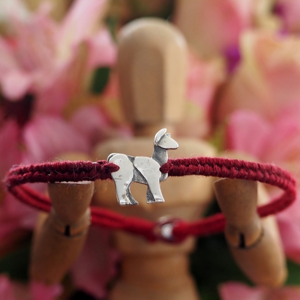 Fine silver llama charm on a red friendship bracelet