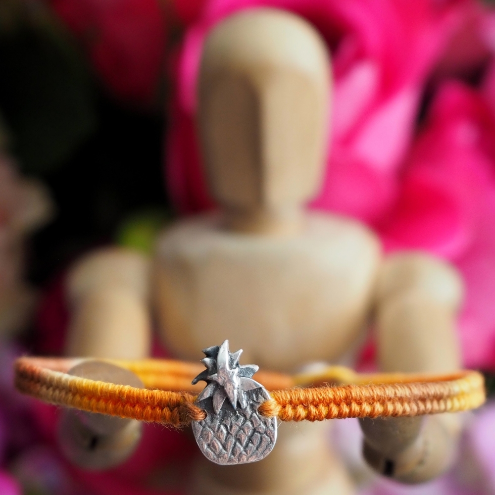 Fine silver pineapple charm on a yellow friendship bracelet