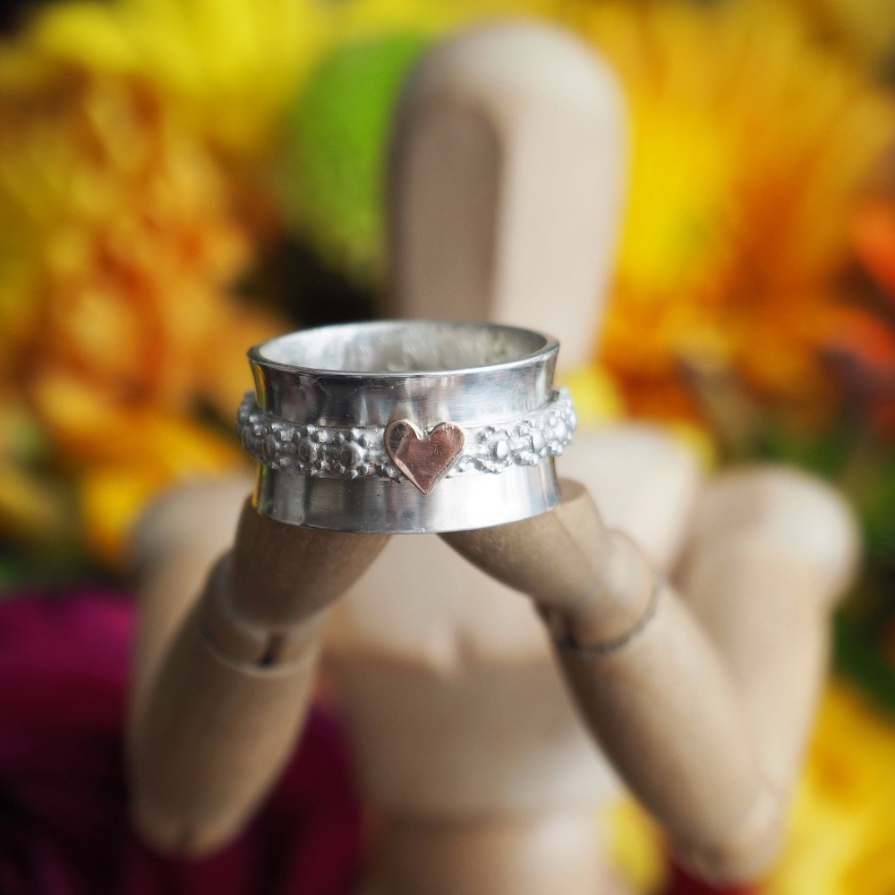Sterling silver spinner ring with gold heart on flower band