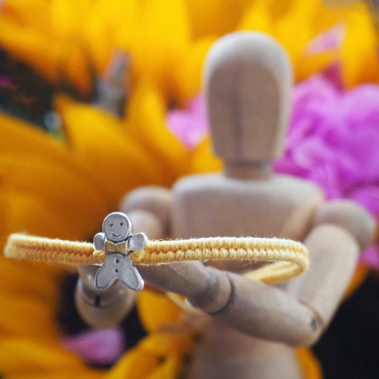 Fine silver gingerbread man on a yellow friendship bracelet