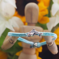 Fine silver orca whale charm on a turquoise friendship bracelet