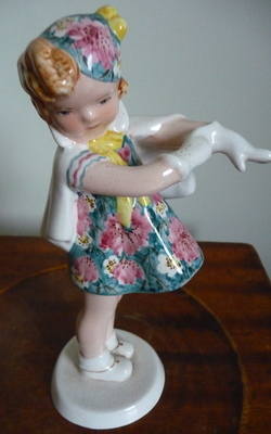 GOLDSHIEIDER FIGURE OF GIRL PUTTING ON GLOVES